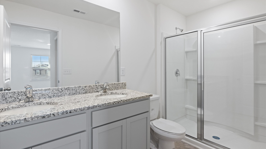 dual sink bathroom with walk in shower