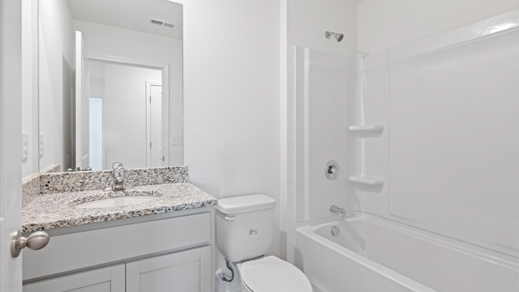 hall bathroom with light grey cabinets and sleek white finishes