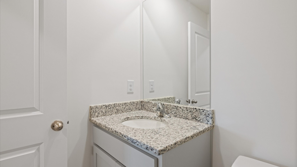 hall bathroom with light grey cabinets and sleek white finishes