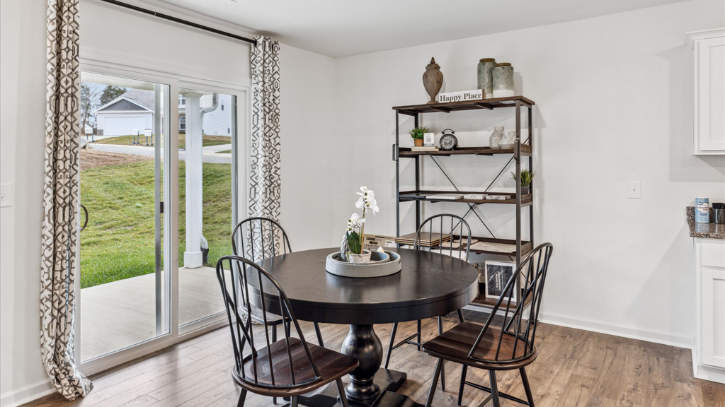 dining area with a table with 4 chairs overlooking sliding glass doors to the backyard