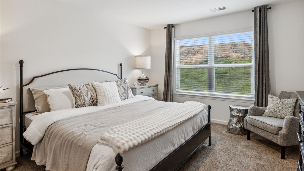 primary bedroom with a large window and a king bed and 2 night stands