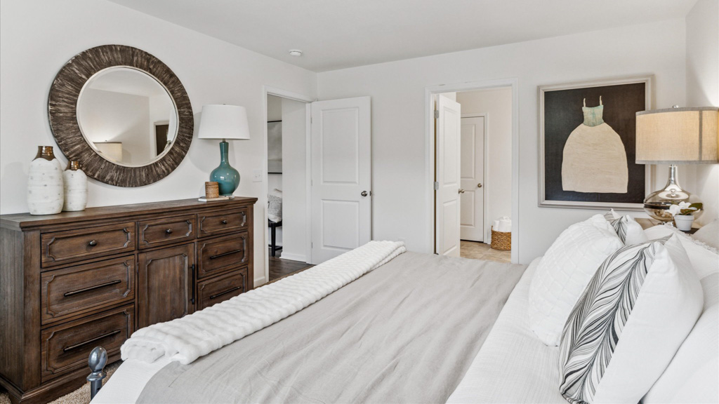 additional view of primary bedroom overlooking the dresser and mirror