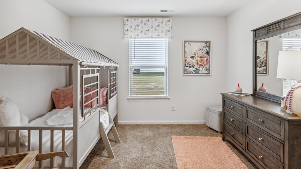 kids room with a bed to the left and dresser and a small window