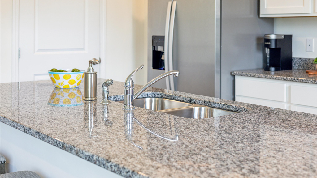 Kitchen with quartz counterops, stainless steel appliances, and shaker style cabinets