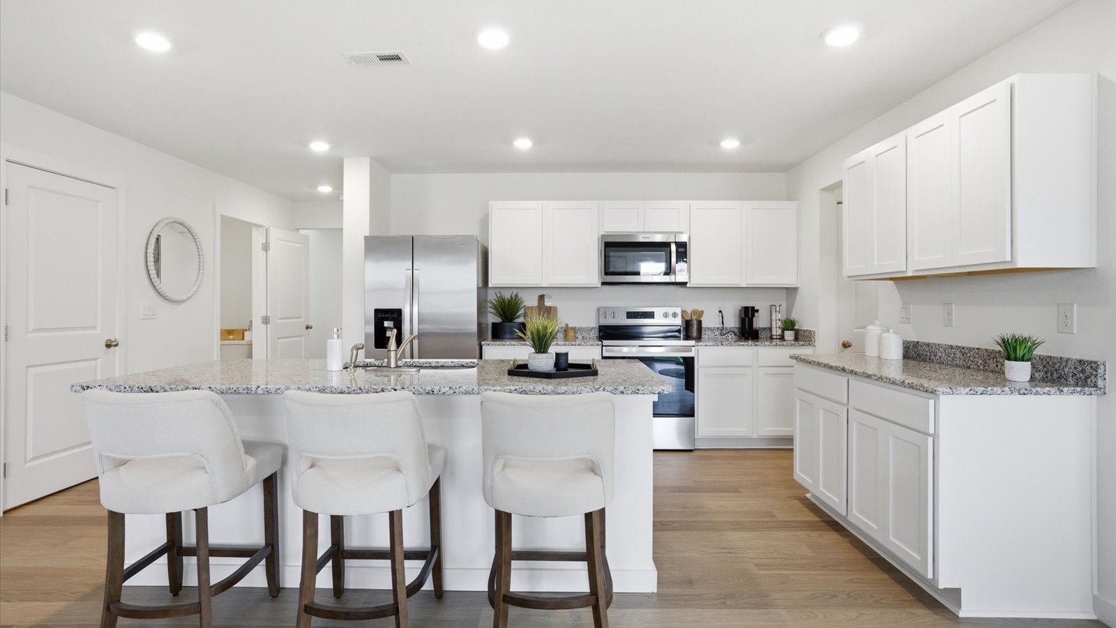 kitchen with stainless steel appliances, granite counter tops, kitchen island, and shaker style cabinets