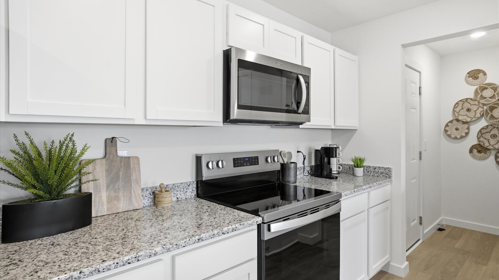 kitchen with stainless steel appliances, granite counter tops, kitchen island, and shaker style cabinets
