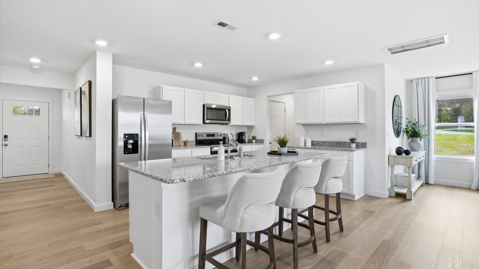 kitchen with stainless steel appliances, granite counter tops, kitchen island, and shaker style cabinets