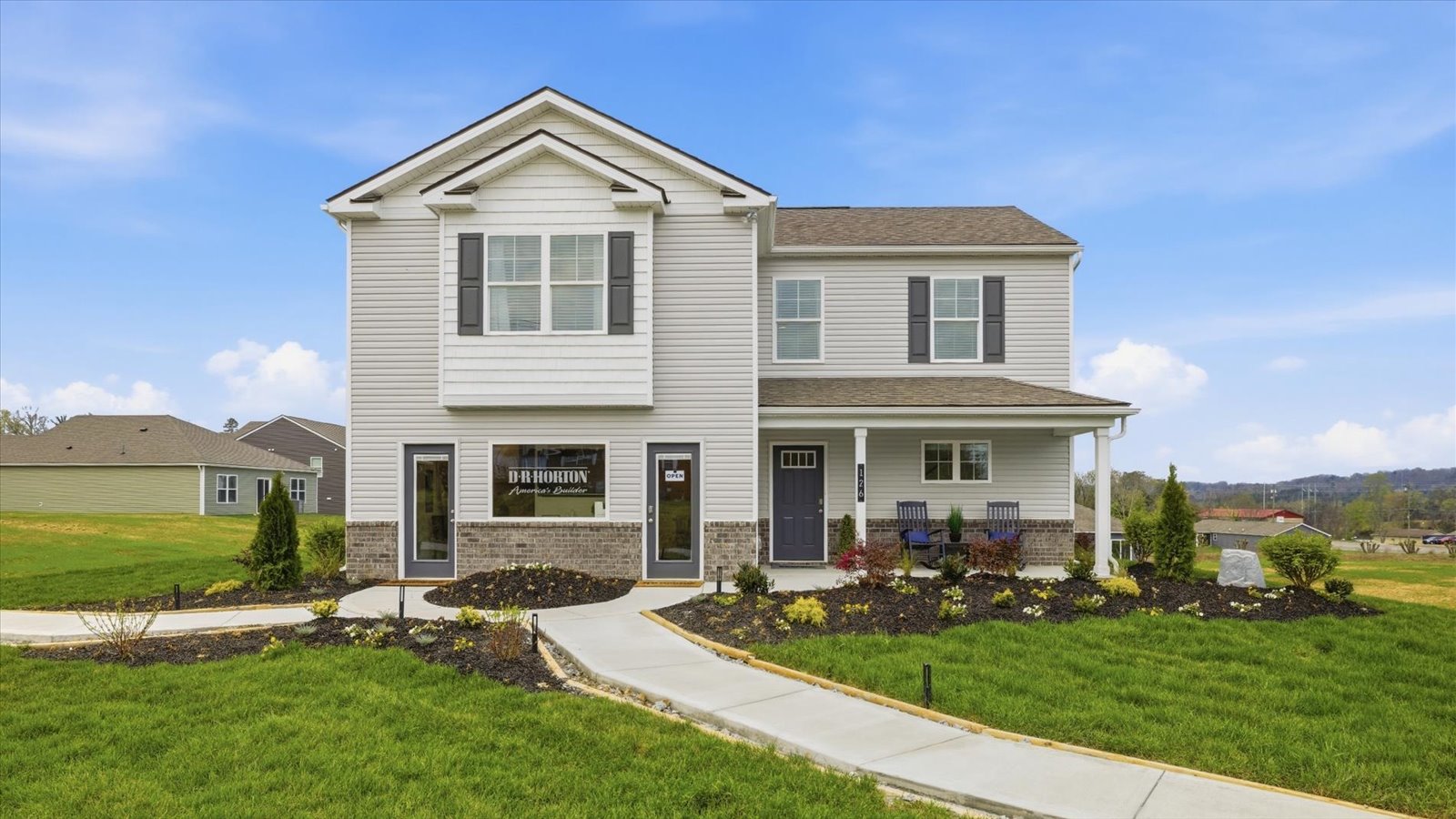front exterior of two story home with vinyl, shake, and brick accents