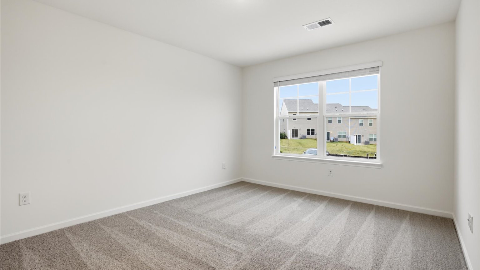 Primary bedroom with plush carpet floors and double light allowing windows