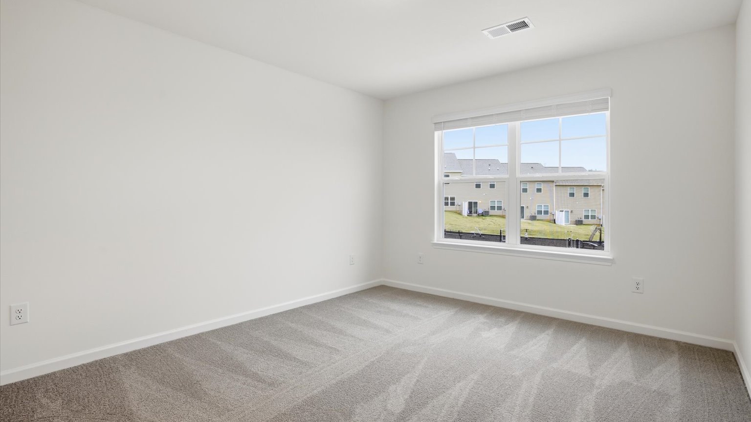 Primary bedroom with plush carpet floors and double light allowing windows