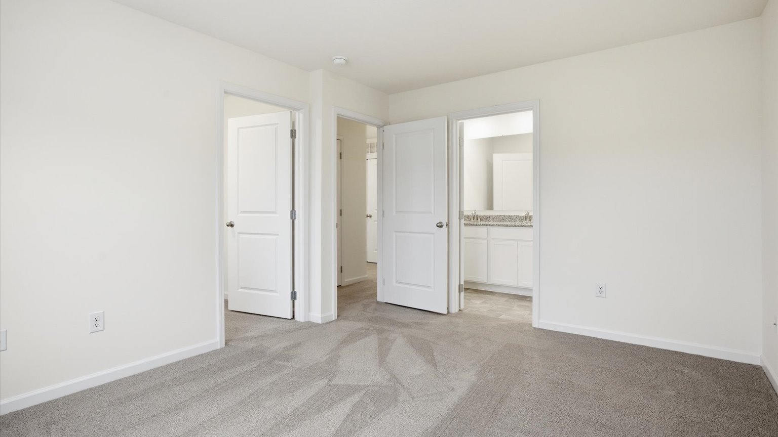 Primary bedroom with plush carpet floors and double light allowing windows