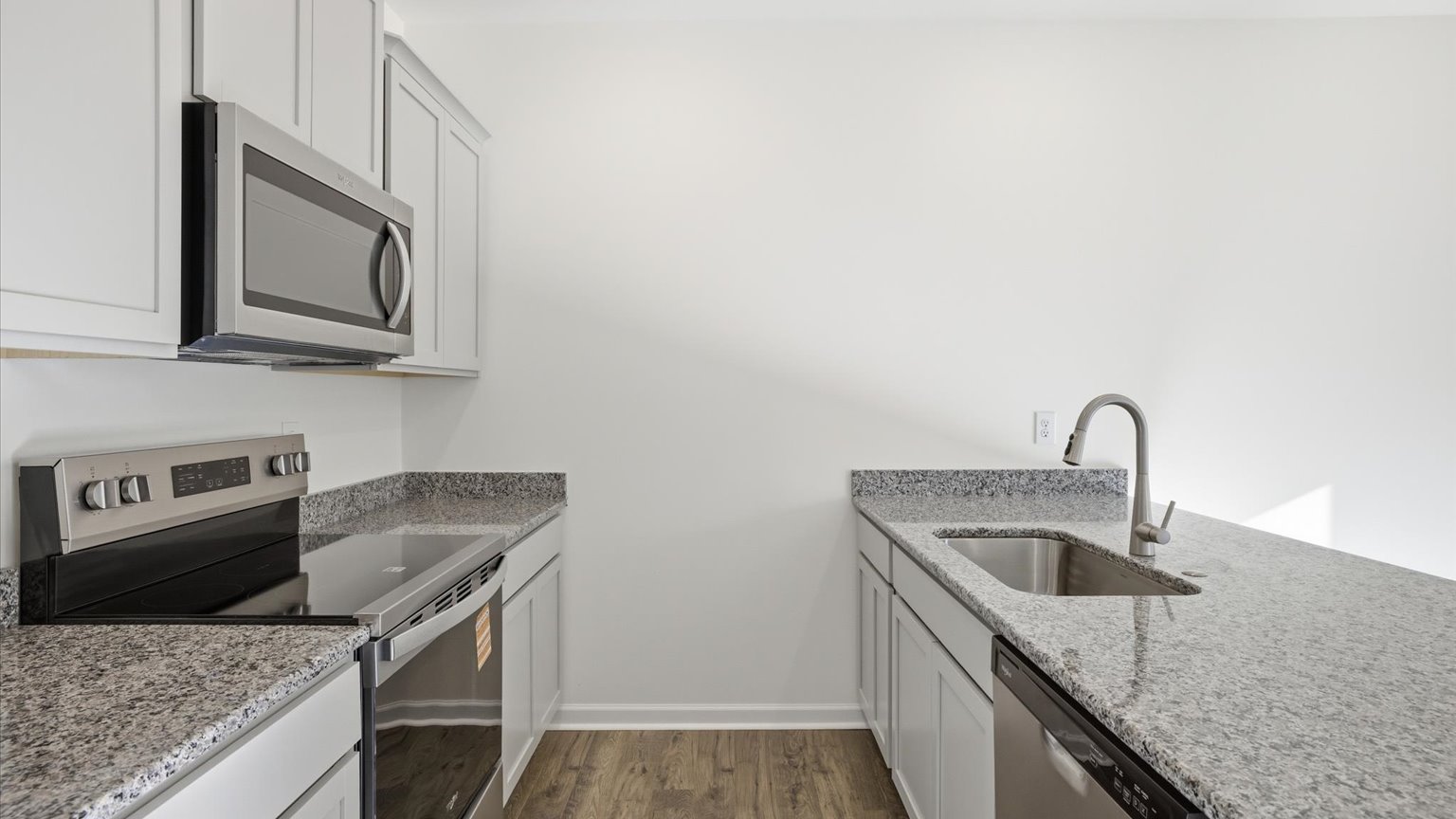 Kitchen with quartz counterops, stainless steel appliances, and shaker style cabinets