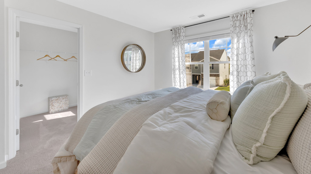 Primary bedroom with plush carpet floors and double light allowing windows