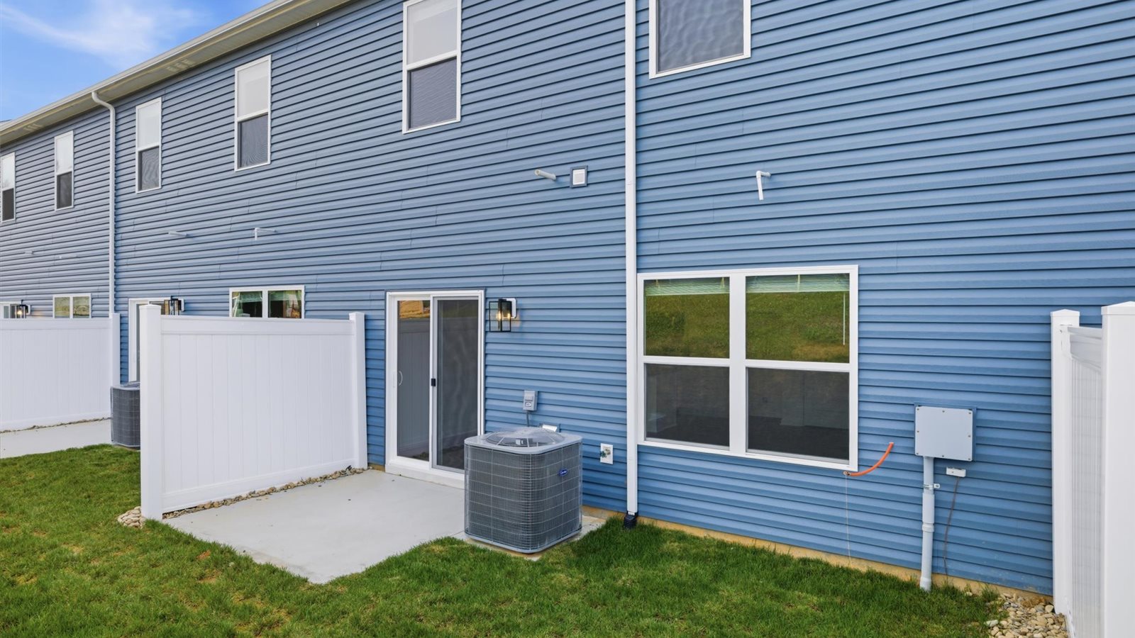 Rear exterior of home and landscaped sodded yard