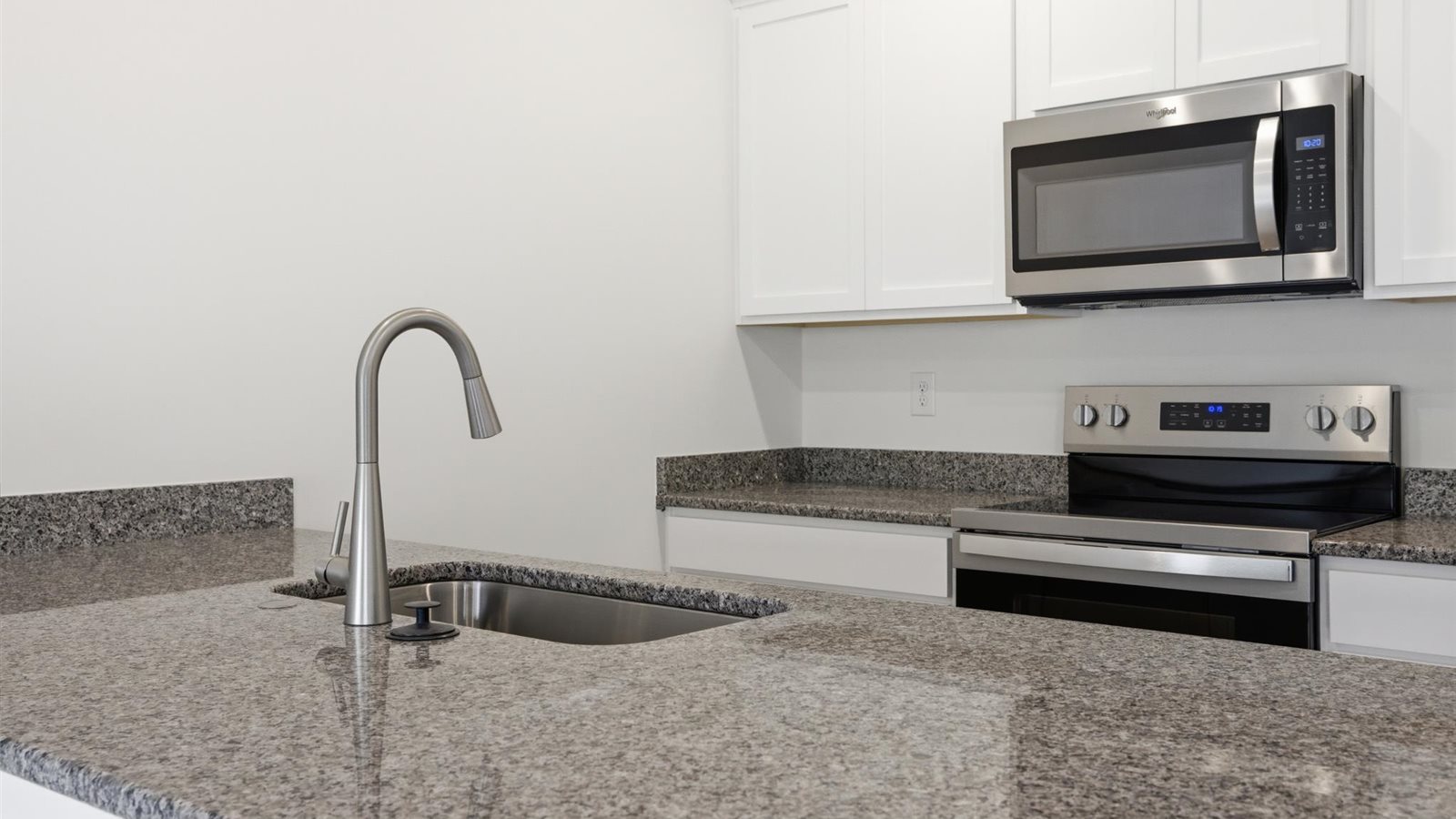 Kitchen with stainless steel appliances, shaker style cabinets, and elevated finishes