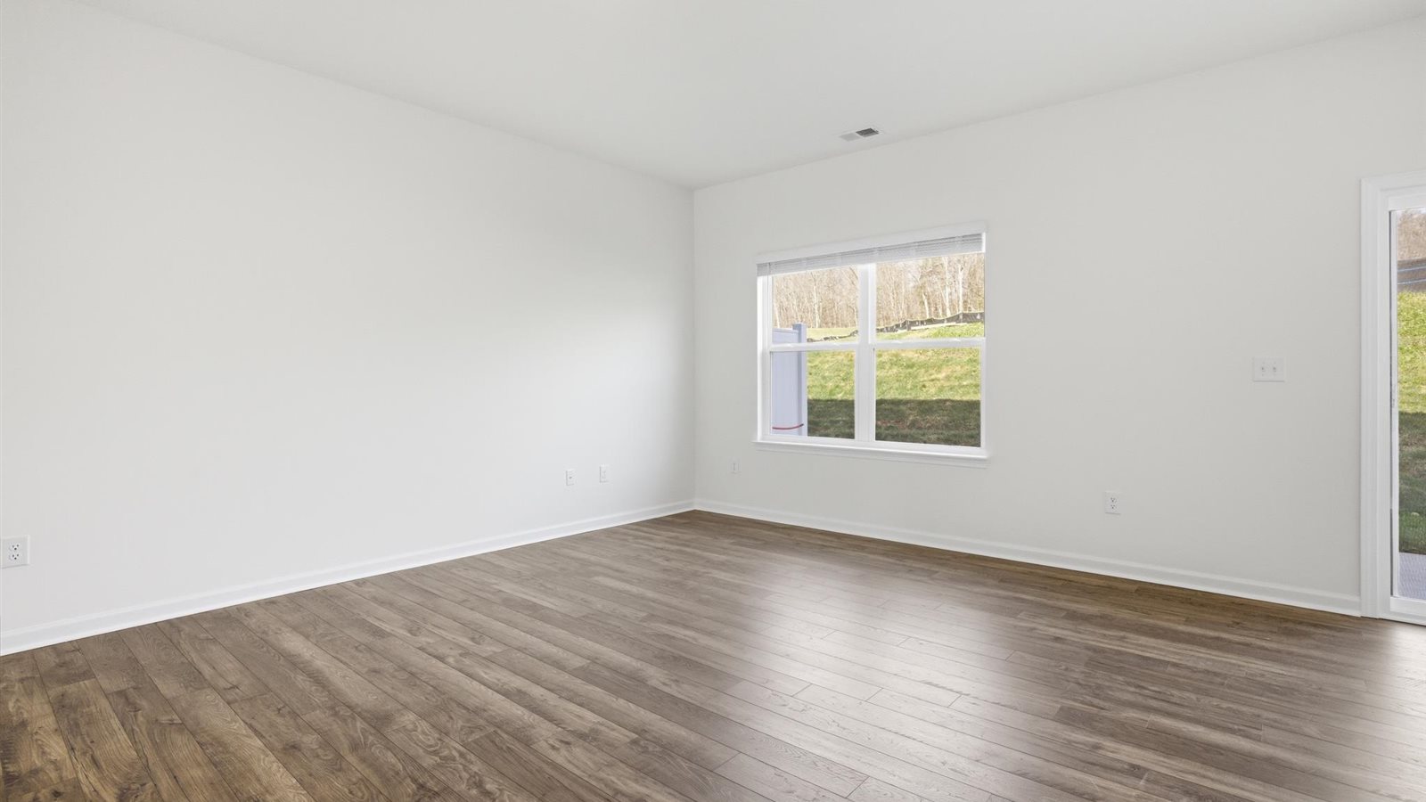 Spacious living and great  room space with light allowing windows