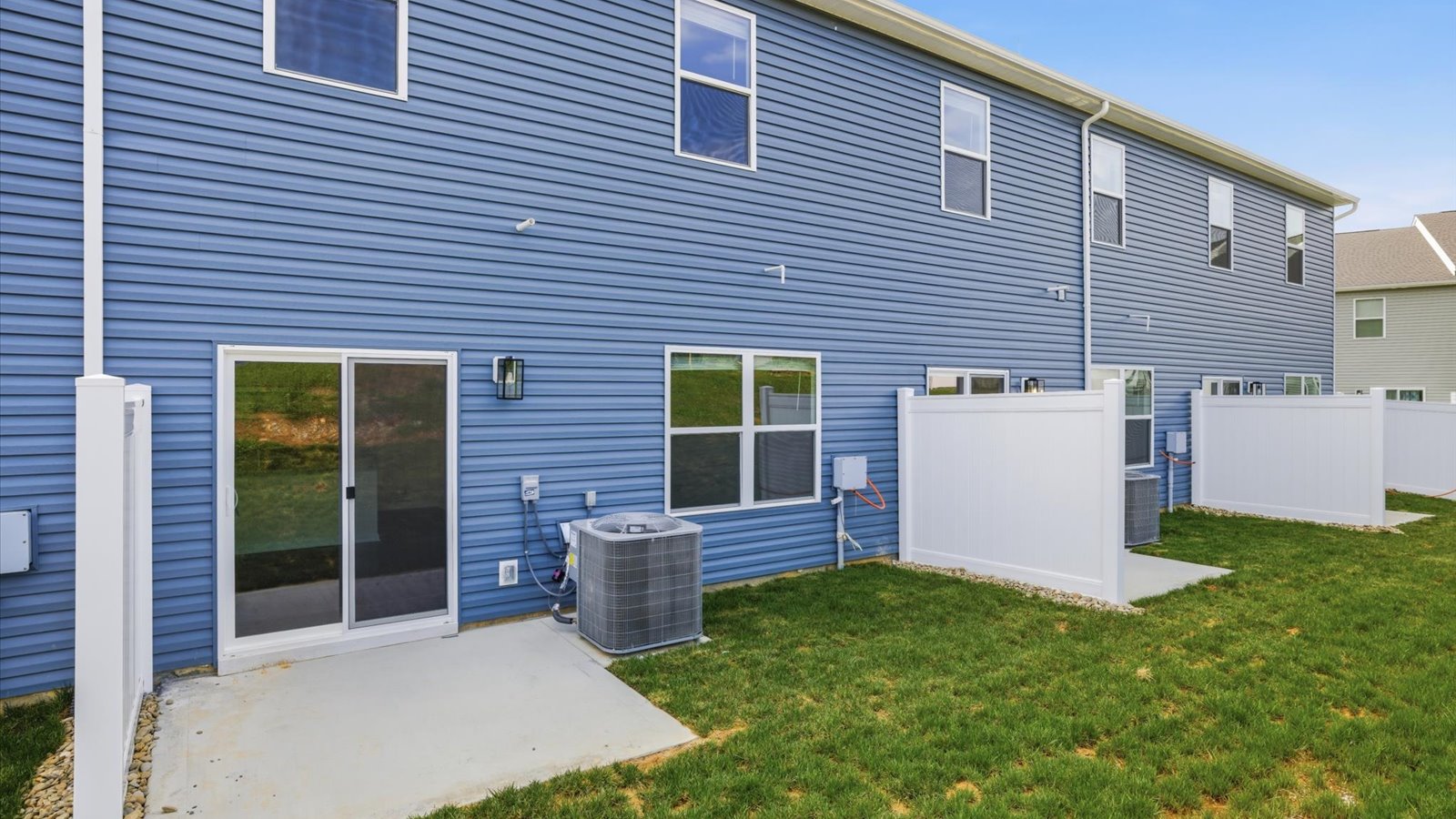 Rear exterior of home and landscaped sodded yard