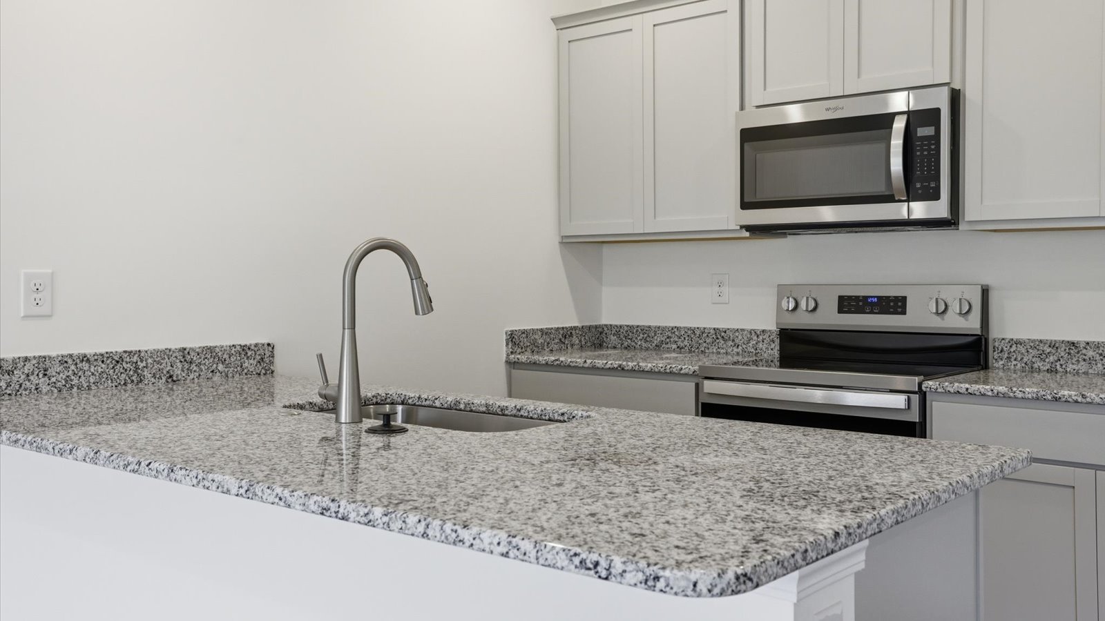 Kitchen with stainless steel appliances, shaker style cabinets, and elevated finishes