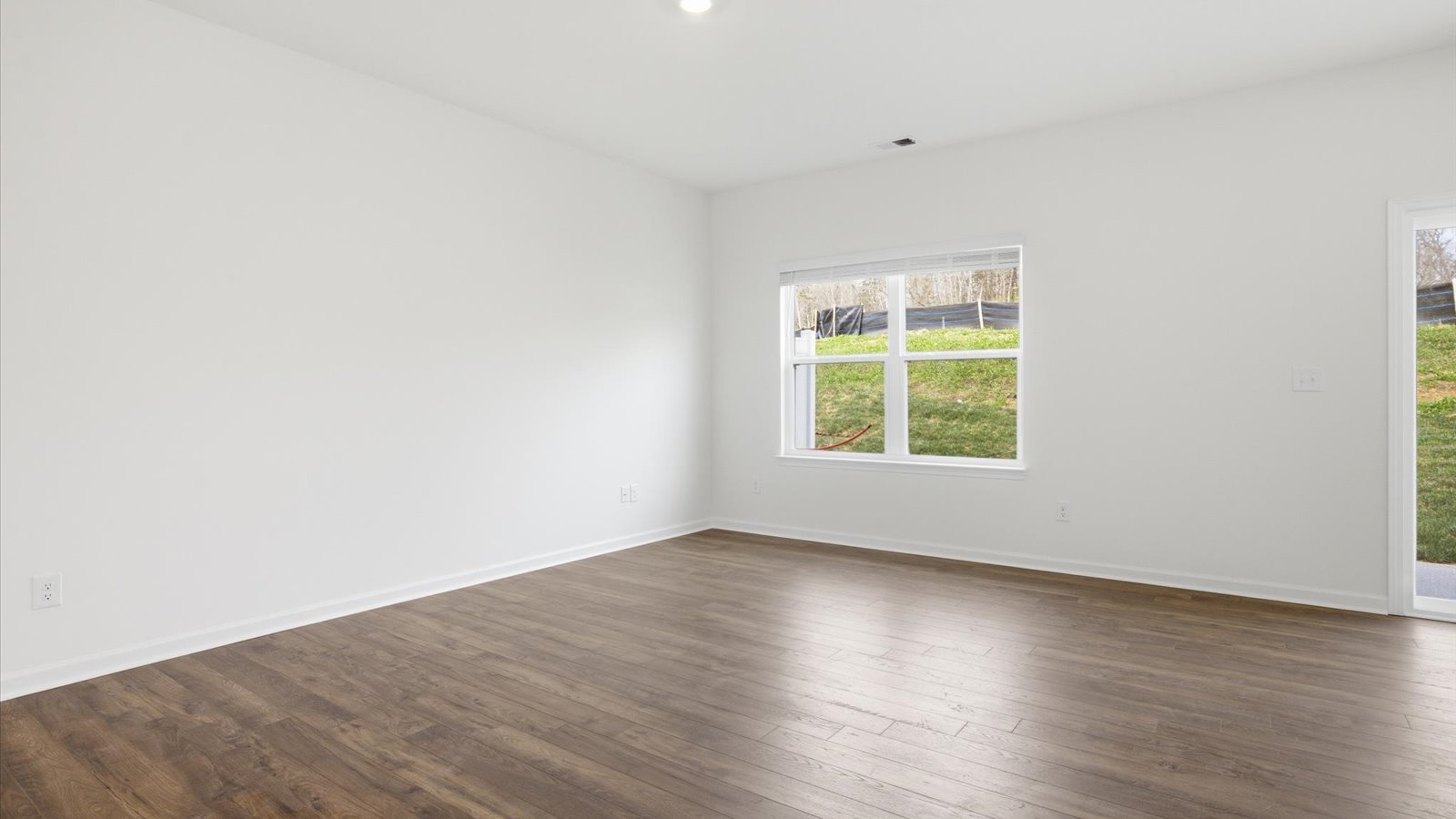 Spacious living and great  room space with light allowing windows