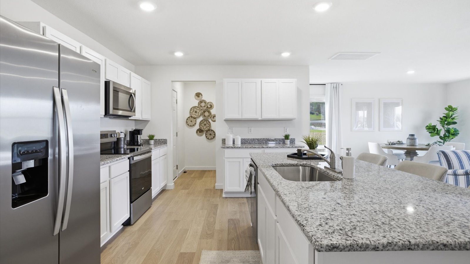 kitchen with stainless-steel appliances, granite counters, kitchen island, and shaker style cabinets