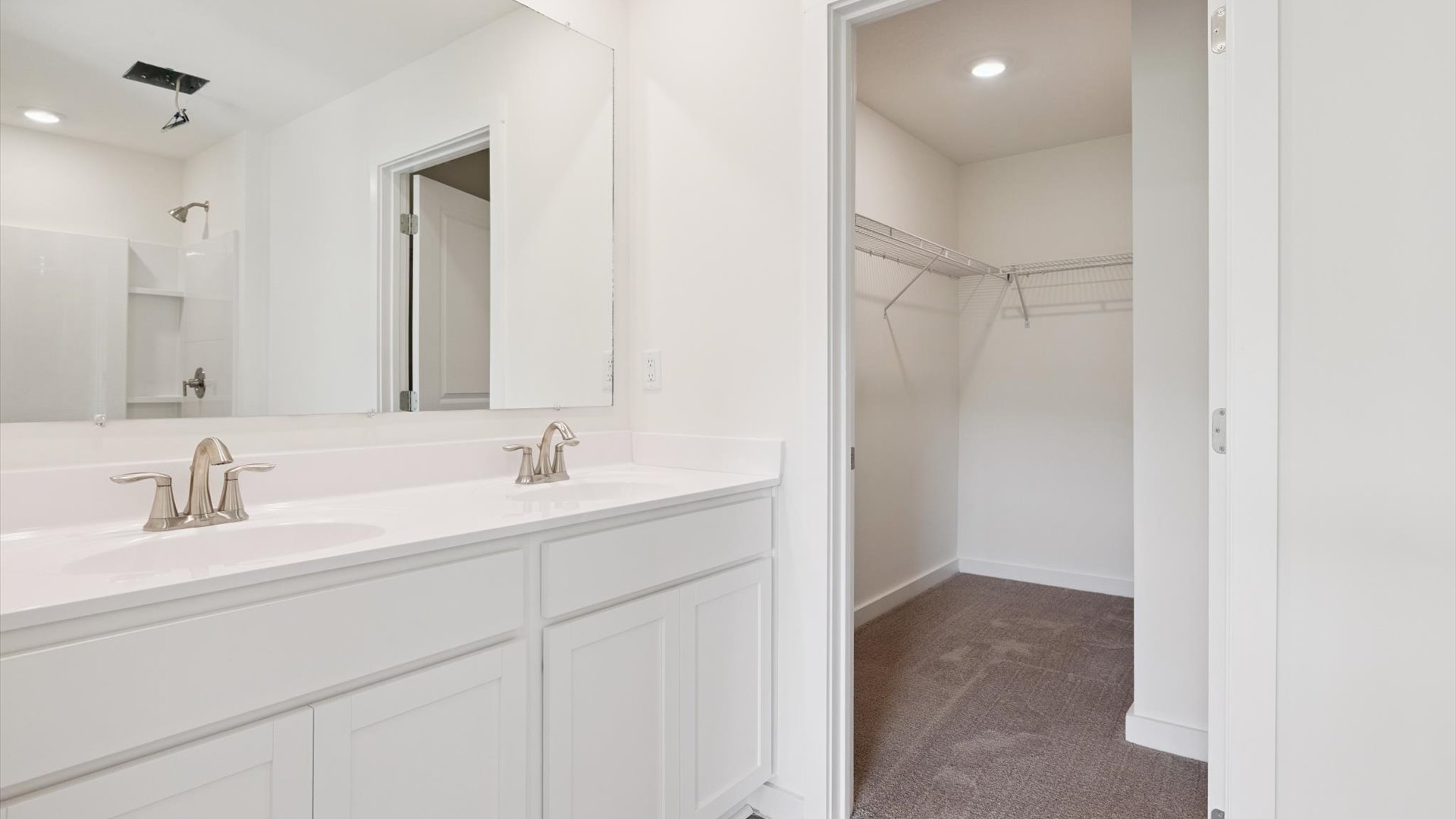 Primary suite walk-in closet in Emory Creek new home with built-in shelving and generous storage