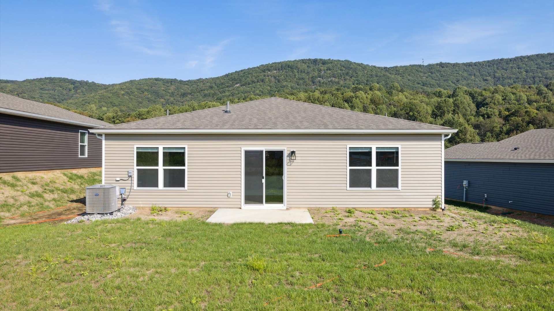 Backyard with concrete patio area offering room for seating, grill setup, and a transition from indoor to outdoor living