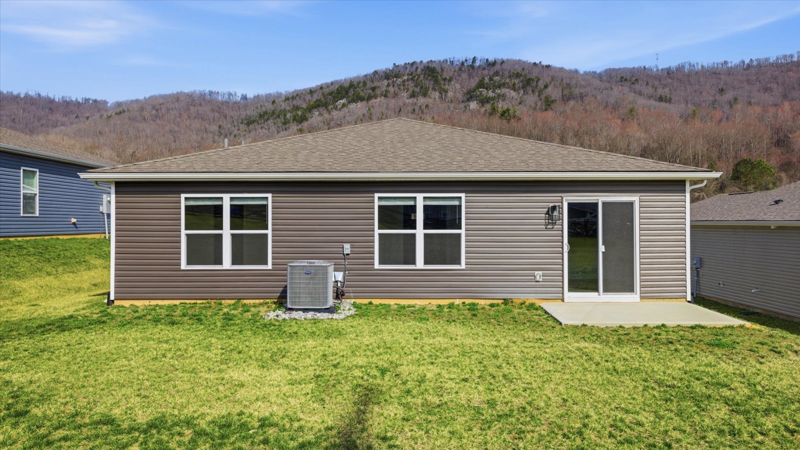 rear exterior of single story home and lush sodded lawn
