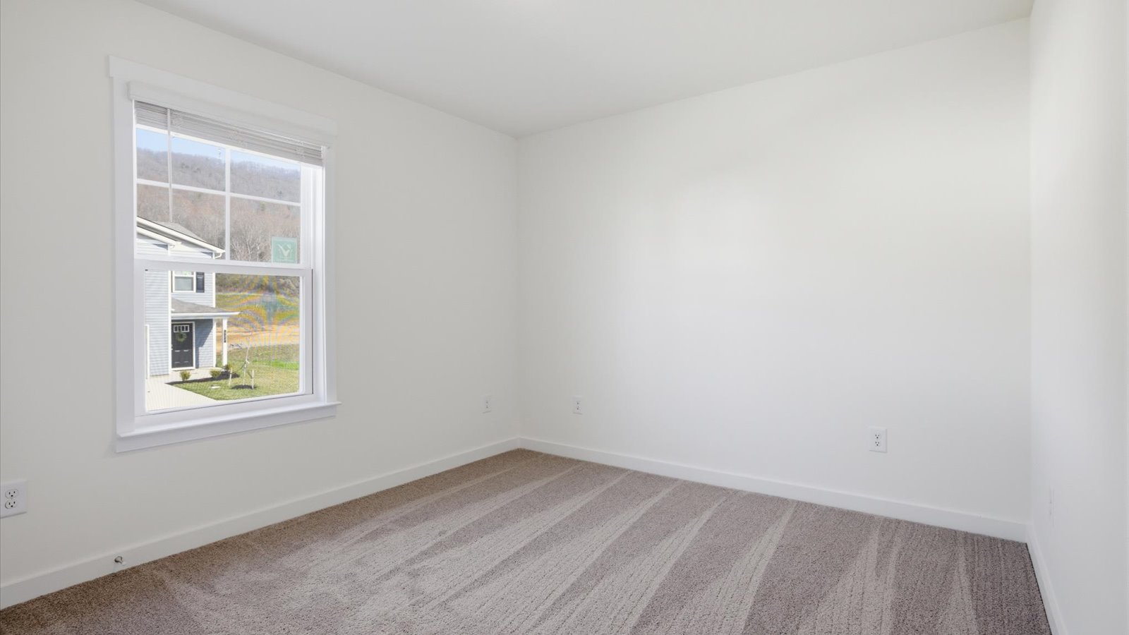 front bedroom with carpet and window