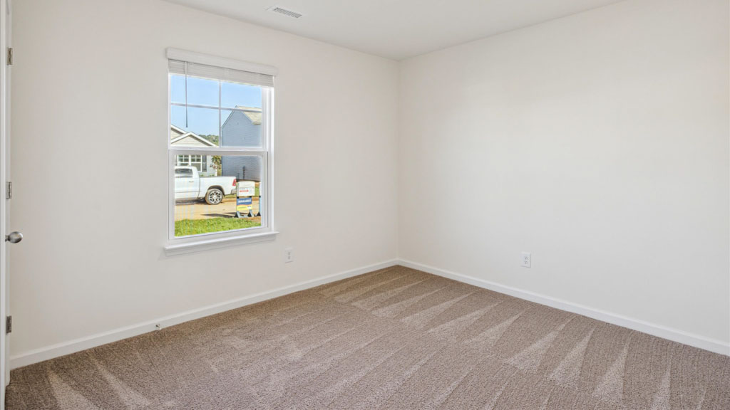 Primary bedroom features ample space, double windows, soft carpet, a stylish walk-in closet, and a private ensuite bath