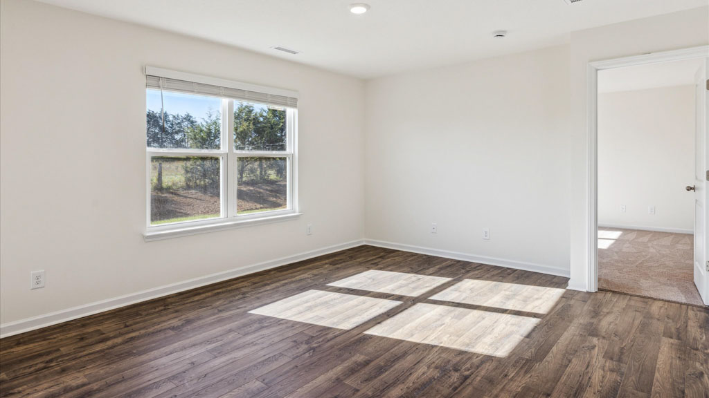 Living room looking into the back yard is near dining and kitchen areas in this new home features natural light, connectivity