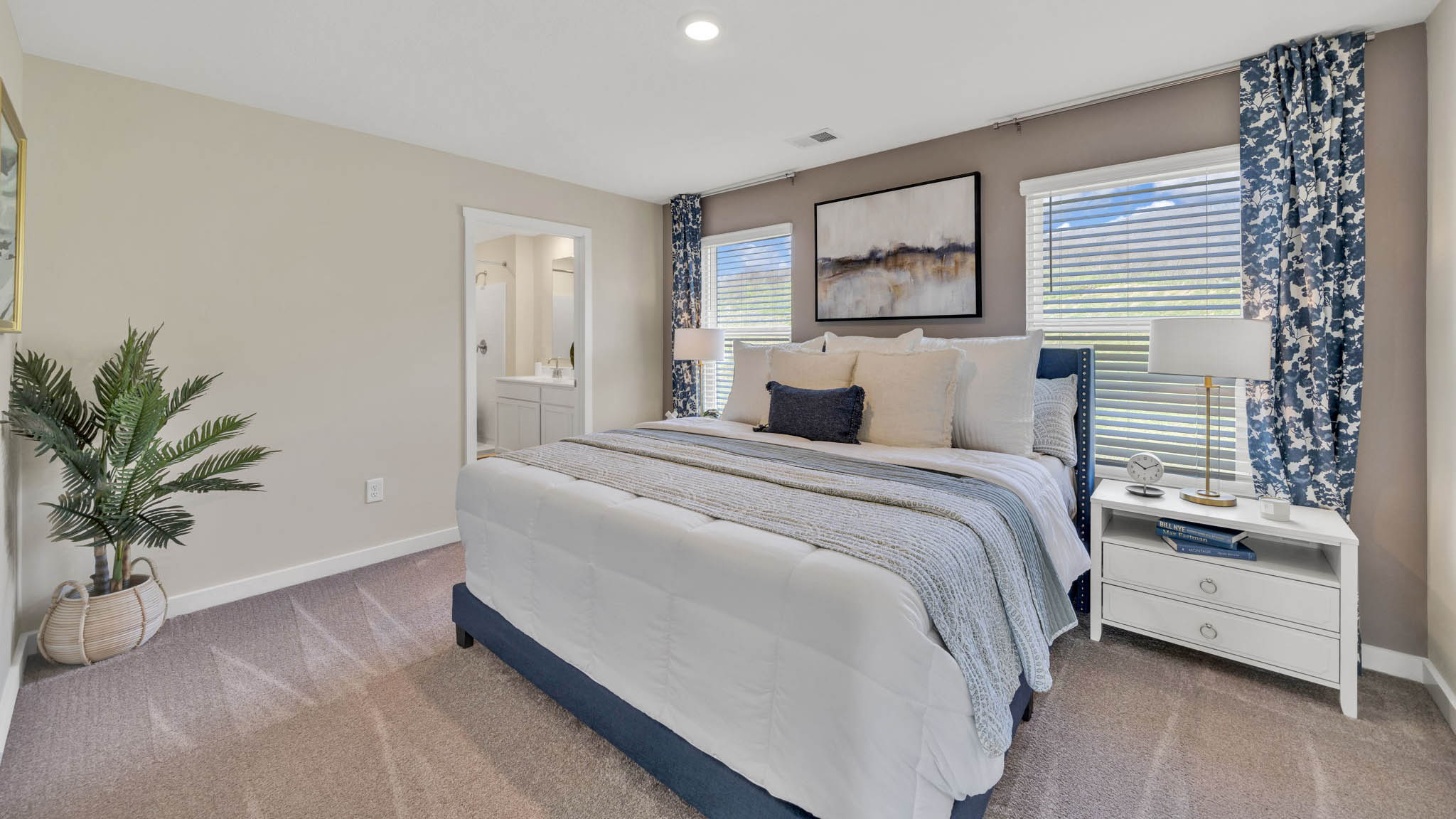Primary bedroom with plush carpet floors and double light allowing windows