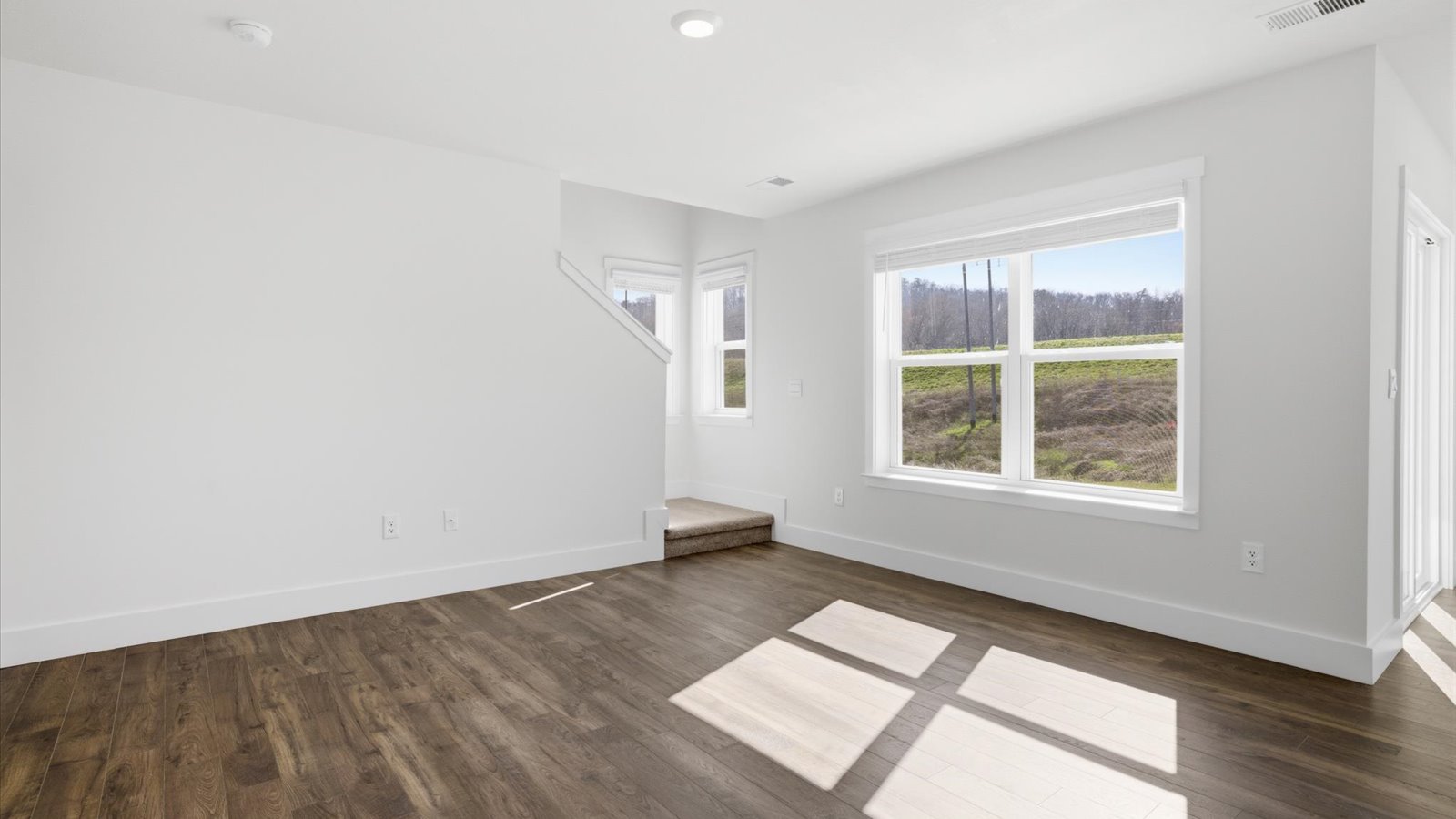 living area with large window and vinyl flooring