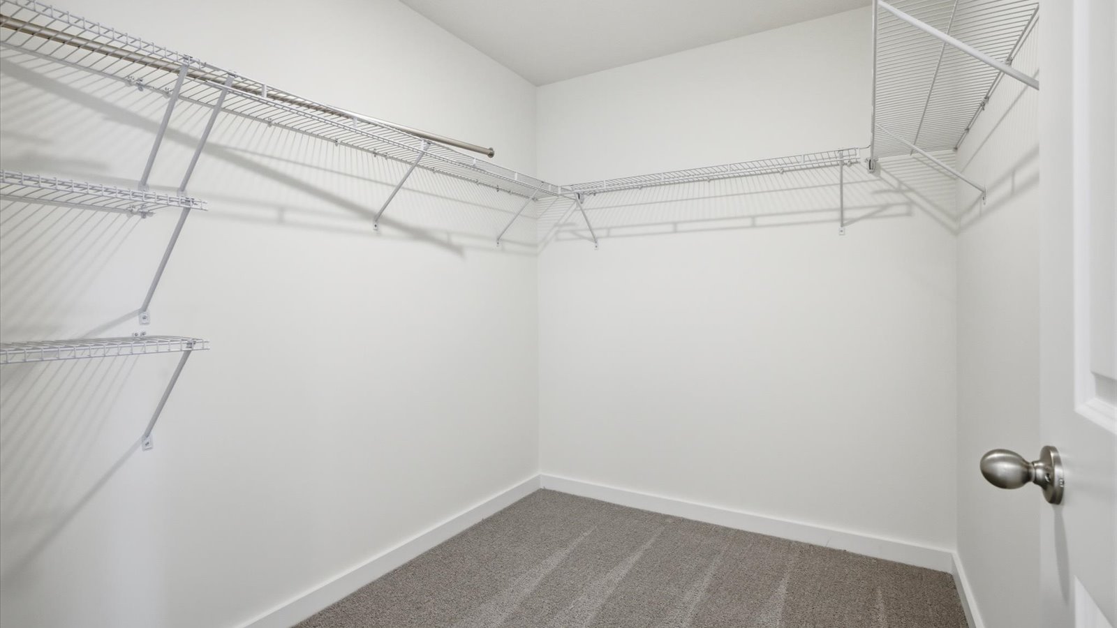 large walk in closet with hanging shelves