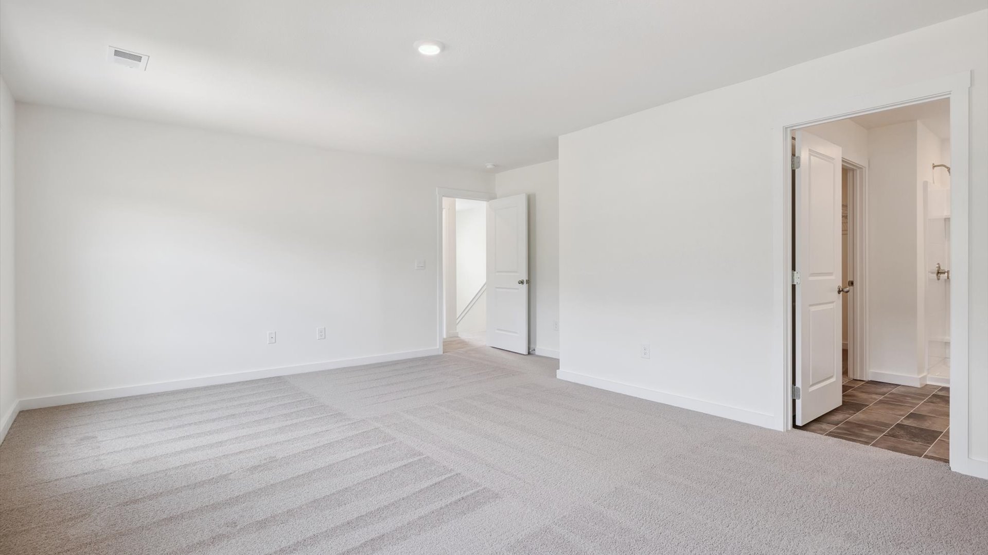 Primary bedroom with private attached bathroom and walk-in closet