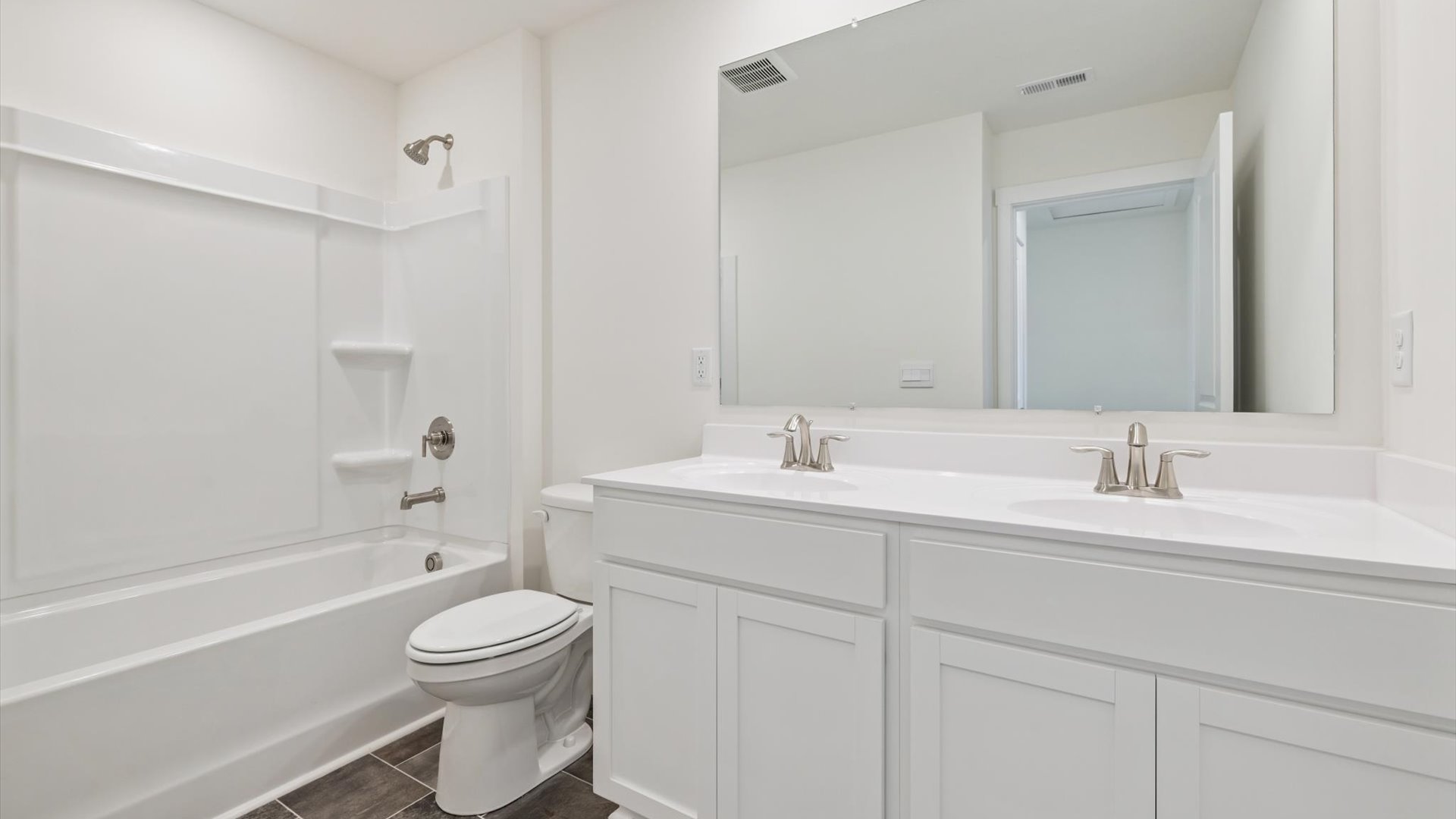 Bathroom with dual vanity and tub-shower combination.