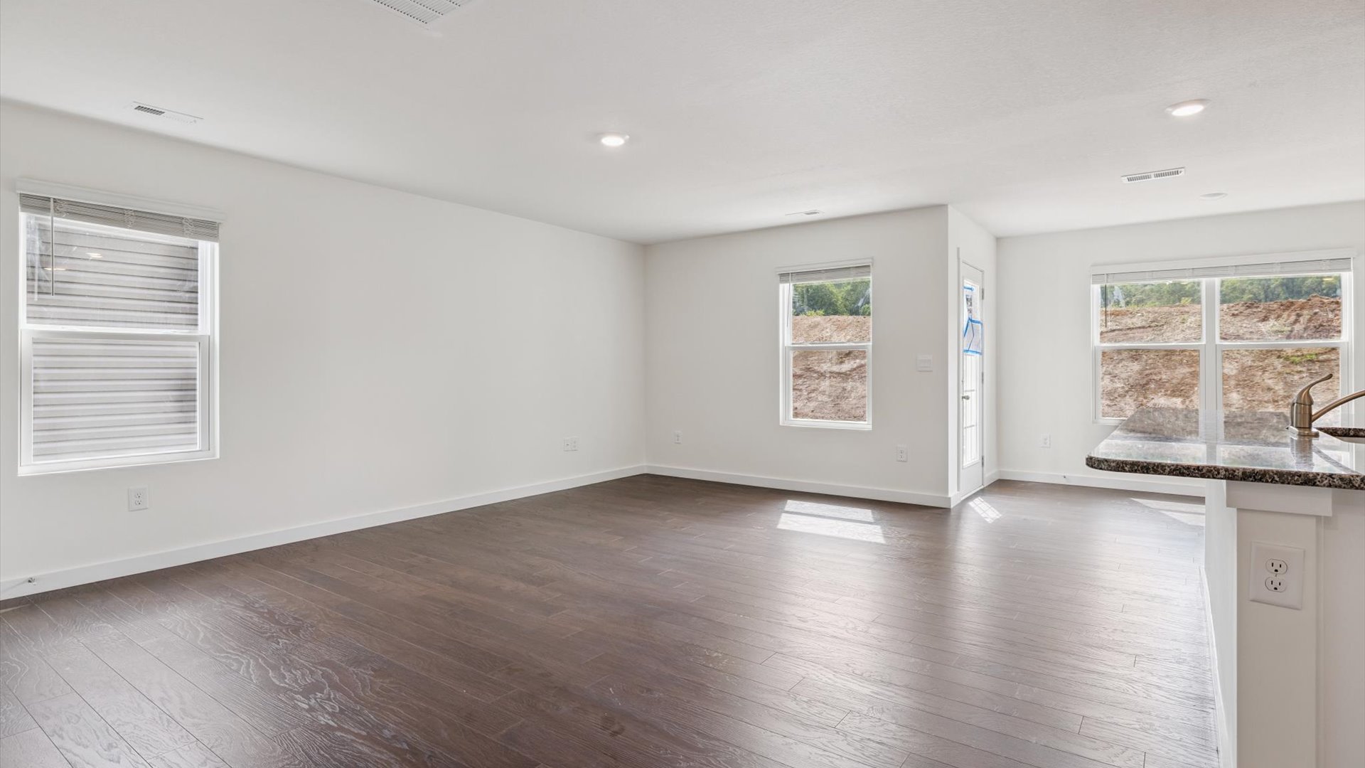Main front level living room adds a bright space, open concept connections to kitchen, living spaces, stairs, backyard