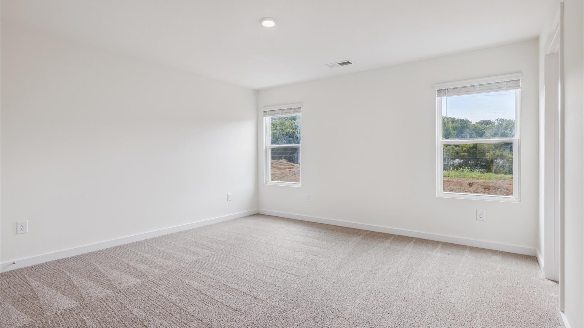 Owner’s suite on main level offers style and function with natural light, spa-inspired ensuite bathroom, walk-in closet