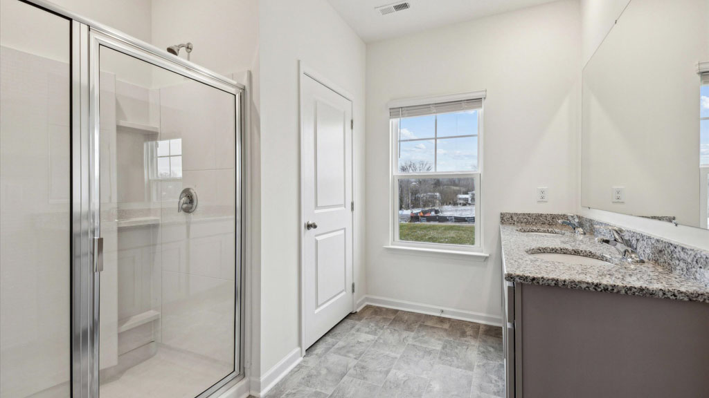 Primary bathroom with double vanity and walk-in shower