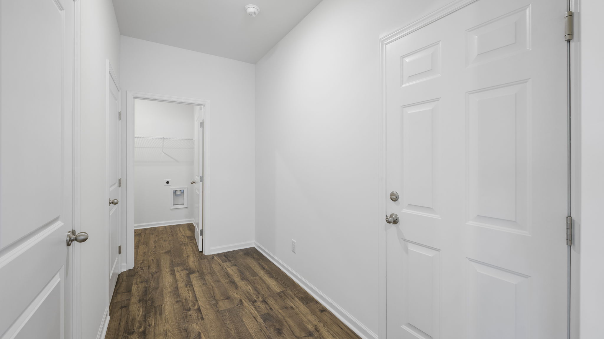 Hallway to laundry room with washer and dryer connections