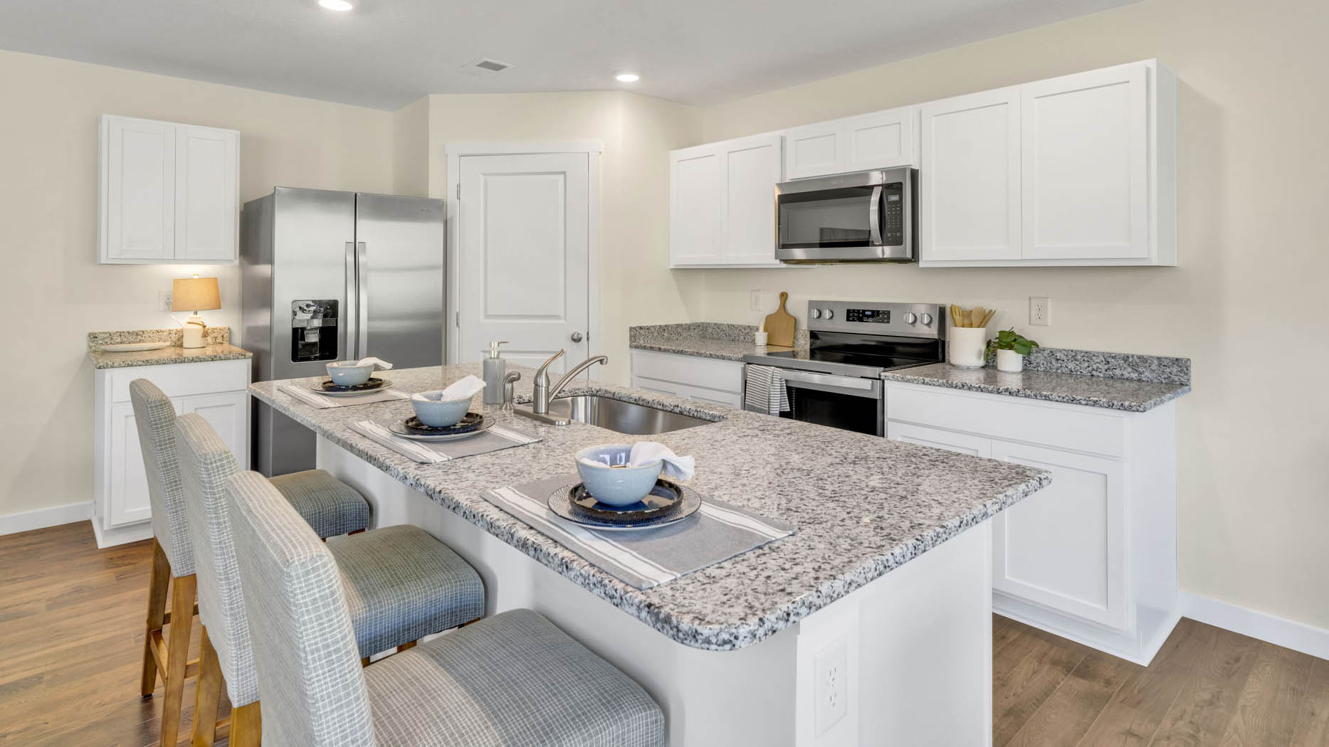 Open concept kitchen with stainless steel appliances, and shaker style cabinets