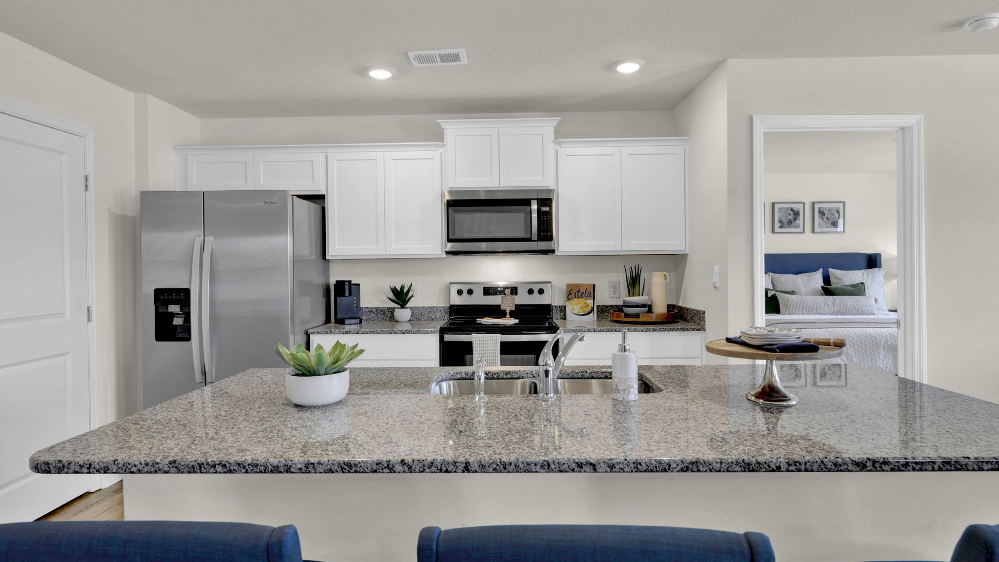 Open concept kitchen with stainless steel appliances, and shaker style cabinets