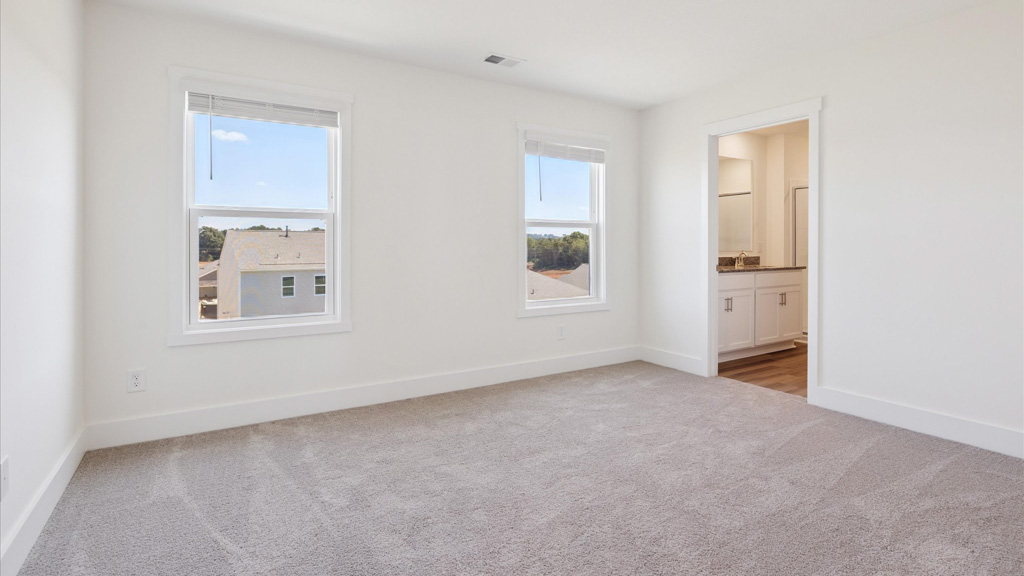Primary bedroom with private attached bathroom and walk-in closet