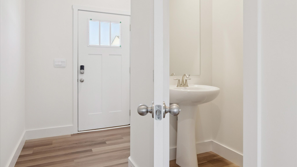 Spacious front foyer and entryway space with half bath for guests