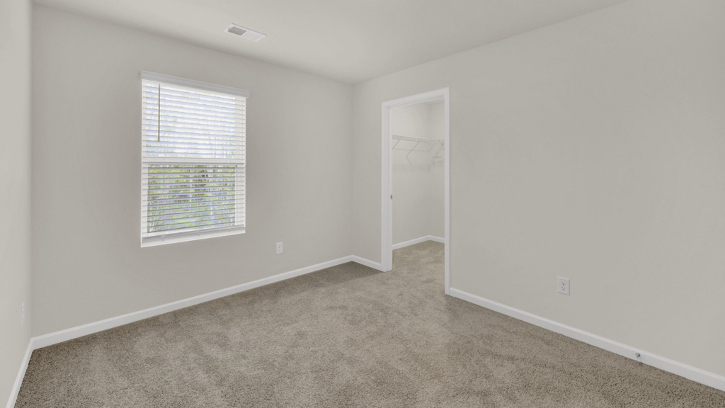 Primary bedroom with plush carpet floors and double light allowing windows
