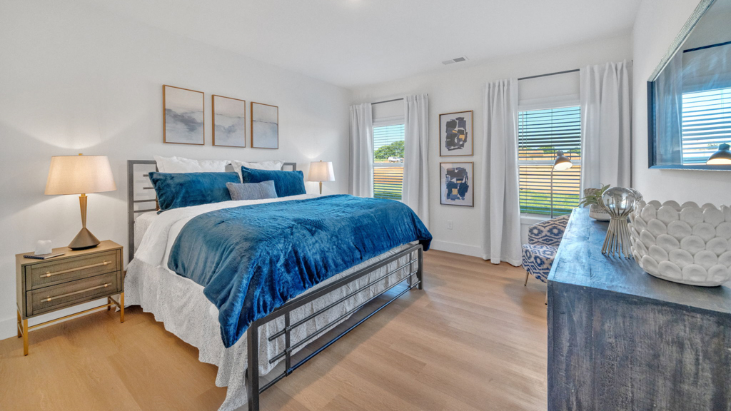Secondary bedroom in Price's Point showcases quality designs with closet space, soft window light, upstairs connectivity