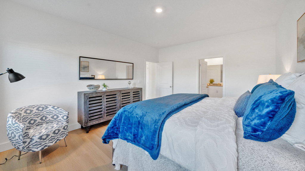 Primary bedroom features ample space, double windows, soft carpet, a stylish walk-in closet, and a private ensuite bath