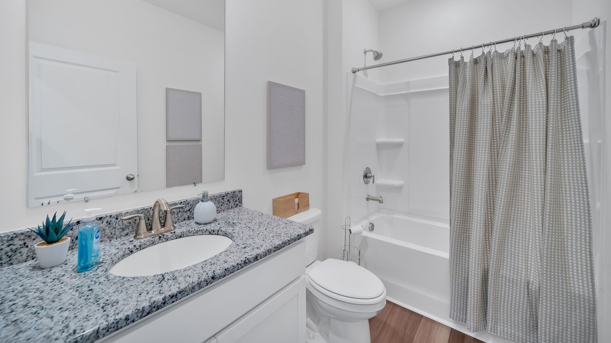 bathroom with double vanity, granite countertops, and shower tub combo