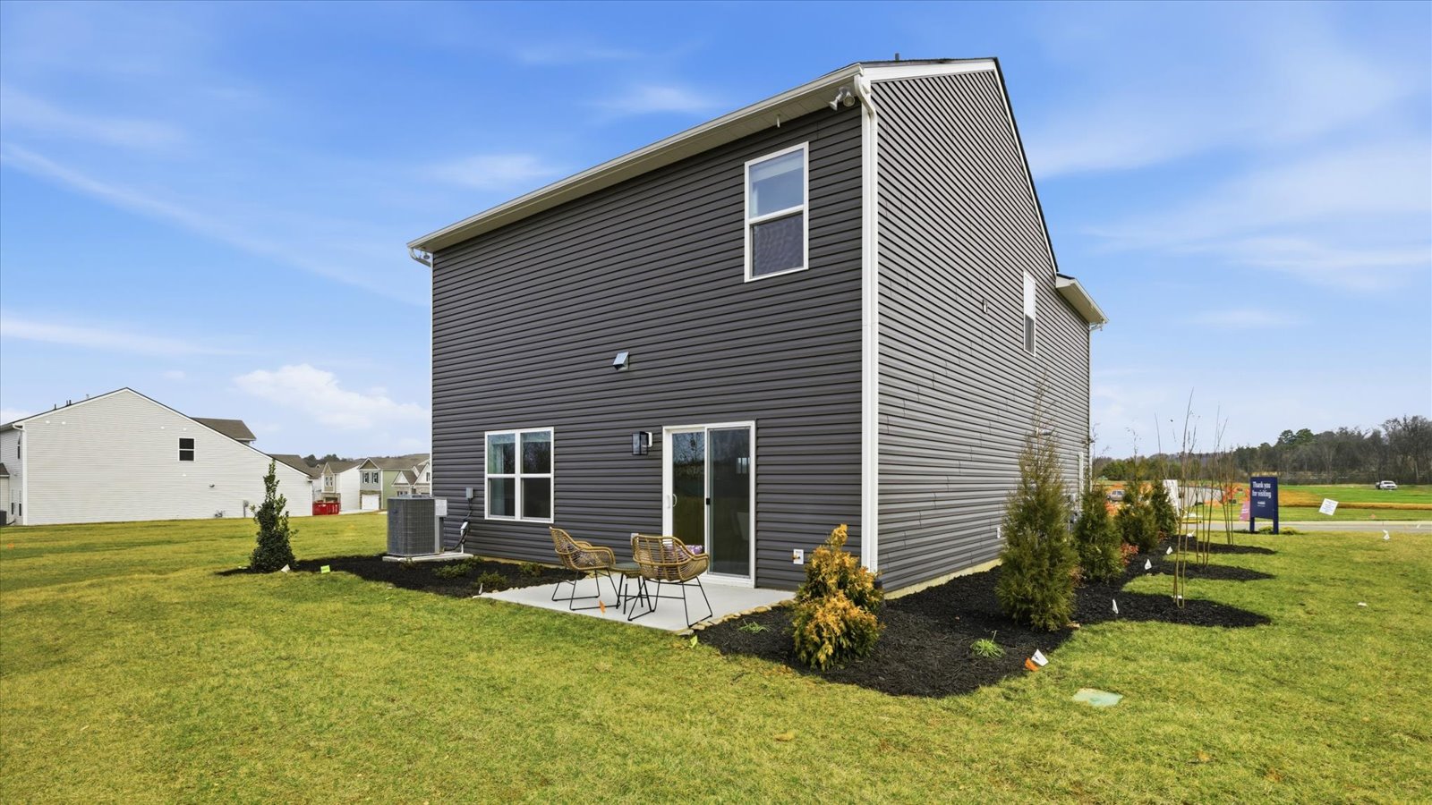 Rear exterior of home and landscaped sodded yard