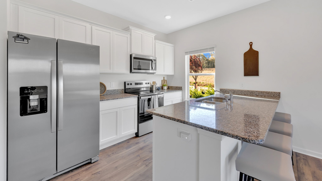 Kitchen with stainless steel appliances, shaker style cabinets, and elevated finishes