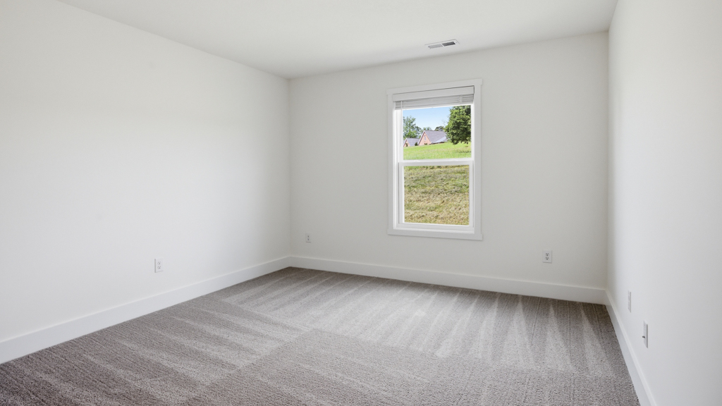 Primary bedroom with plush carpet floors and double light allowing windows